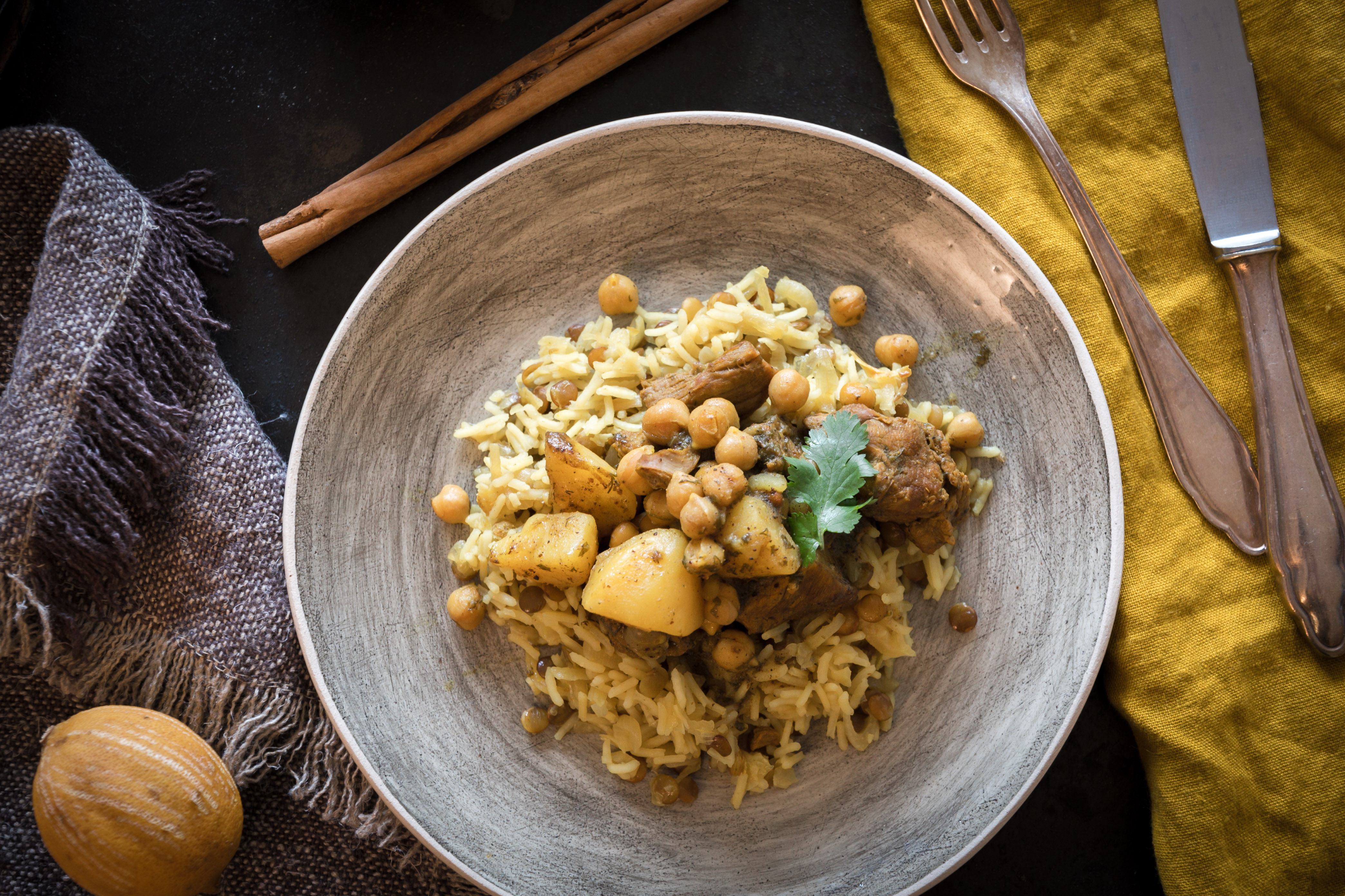 Persischer Rindfleischeintopf serviert auf Reis mit Linsen und frittierten Zwiebeln